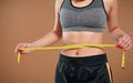 Close up of slim woman measuring her waist`s size with tape measure. Royalty Free Stock Photo