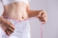 Close up slim young woman measuring her thin waist with a tape measure. Healthcare and woman diet lifestyle concept to reduce Royalty Free Stock Photo