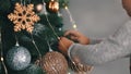 Close up slove motion boy hanging a toy on a christmas tree