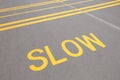 Close up on a slow down speed indicator sign painted on a road