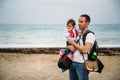 Close up of small baby girl in sweatshirt in father`s hands on the sea coast Royalty Free Stock Photo