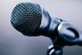 Close-up of small black desk microphone with cable and low stand on a black table. Modern style, Communication concept Royalty Free Stock Photo