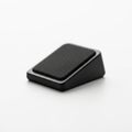 A close up of a small black wedge shaped object on a white surface Royalty Free Stock Photo