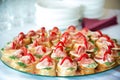 Close up of small canapes arranged on a mirror plate over light background