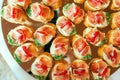 Close up of small canapes arranged on a mirror plate over light background Royalty Free Stock Photo