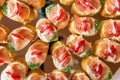 Close up of small canapes arranged on a mirror plate over light background Royalty Free Stock Photo