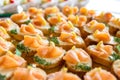 Close up of small canapes arranged on a mirror plate over light background Royalty Free Stock Photo