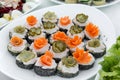 Close up of small canapes arranged on a plate over light background Royalty Free Stock Photo