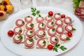 Close up of small canapes arranged on a plate over light background Royalty Free Stock Photo