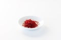Close up of a small dish filled with Saffron threads against a white background. Royalty Free Stock Photo