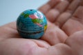 Small globe in hand symbolizing global connection. Royalty Free Stock Photo