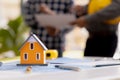 Close-up of a small house model, an architect engineer designs the house and its interior and draws a floor plan through a design Royalty Free Stock Photo