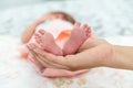 Close-up of the small legs of a newborn baby in the hands of a woman or mother. Moments with a child Royalty Free Stock Photo