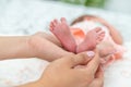 Close-up of the small legs of a newborn baby in the hands of a woman or mother. Moments with a child Royalty Free Stock Photo