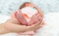 Close-up of the small legs of a newborn baby in the hands of a woman or mother. Moments with a child Royalty Free Stock Photo