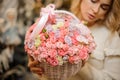 Close-up of small pink roses inside white wicker basket in hands of woman Royalty Free Stock Photo