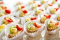 Close up of small sweet canapes arranged on a mirror plate over light background Royalty Free Stock Photo