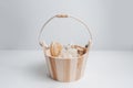 Close-up of small wooden bucket with set of bath accessories; hairbrush, washcloth, pumice stone and massager tool. Royalty Free Stock Photo