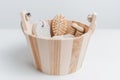 Close-up of small wooden bucket with some bath accessories; hairbrush, washcloth, pumice stone and massager tool. Royalty Free Stock Photo