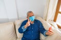 Close-up of a smart older man wearing a face mask and having his picture taken with his cell phone