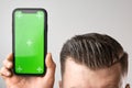 Close up a smartphone with a chroma key near perfect mans haircut. Copy space for advertising of barbershop.