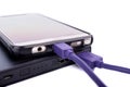 Close up of smartphone mobile charging by power bank with purple or violet usb cable isolated on white background Royalty Free Stock Photo