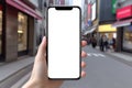 A close-up smartphone mockup in hand against the backdrop of a city street