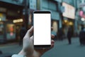 A close-up smartphone mockup in hand against the backdrop of a city street