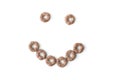 Close-up of a smile of round, brown breakfast cereals.