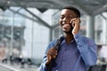 Close up of smiling african american businessman talking on cellphone at station Royalty Free Stock Photo