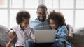Close up smiling African American father with kids using laptop Royalty Free Stock Photo