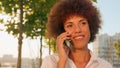 Close up smiling African American happy ethnic girl businesswoman walking in sun sunshine city remote talk talking Royalty Free Stock Photo