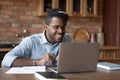 Close up smiling African American man wearing glasses using laptop Royalty Free Stock Photo