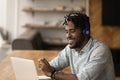 Close up smiling African American man wearing headphones using laptop Royalty Free Stock Photo