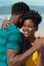 Close-up of smiling african american young woman with short hair dancing with boyfriend at beach Royalty Free Stock Photo