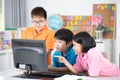 Close up of Smiling asian pupils using a desktop computer.