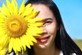 Close-up of a smiling asian woman face with a sunflower Royalty Free Stock Photo