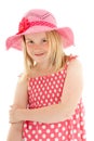 Close up of smiling beautiful young blonde girl wearing big pink floppy hat and a polka dot dress. Isolated on white studio Royalty Free Stock Photo