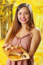 Close up of smiling beautiful young woman holding in her hands a grilled sausages on wooden cutting board, BBQ in the Royalty Free Stock Photo