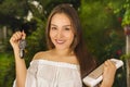 Close up of a smiling beautiful young woman holding her keys in one hand and the tablet and purse in her other hand in Royalty Free Stock Photo