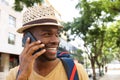 Close up smiling black man with hat talking on cellphone Royalty Free Stock Photo