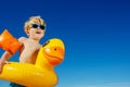 Close-up of a smiling blond boy with inflatable yellow duck buoy Royalty Free Stock Photo