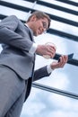 Smiling business man reading SMS on his smartphone Royalty Free Stock Photo