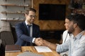 Close up smiling manager and African American couple handshaking Royalty Free Stock Photo