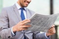 Close up of smiling businessman reading newspaper