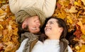 Close up of smiling couple lying in autumn park Royalty Free Stock Photo