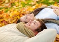 Close up of smiling couple lying in autumn park Royalty Free Stock Photo