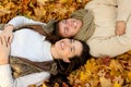 Close up of smiling couple lying in autumn park Royalty Free Stock Photo
