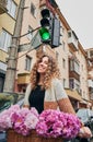 Smiling woman with curly hair riding bicycle in city. Royalty Free Stock Photo