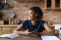 Close up smiling dreamy African American woman distracted from phone Royalty Free Stock Photo